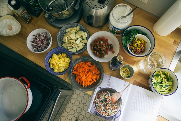 An overhead landscape shot of prepped vegetables and ingredients laid out and ready to go before cooking.