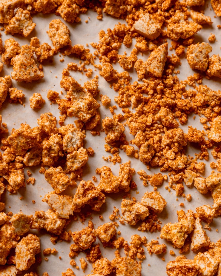 An overhead shot of pieces of tofu covered in spices, arrowroot starch and cornmeal, before being cooked in the oven.