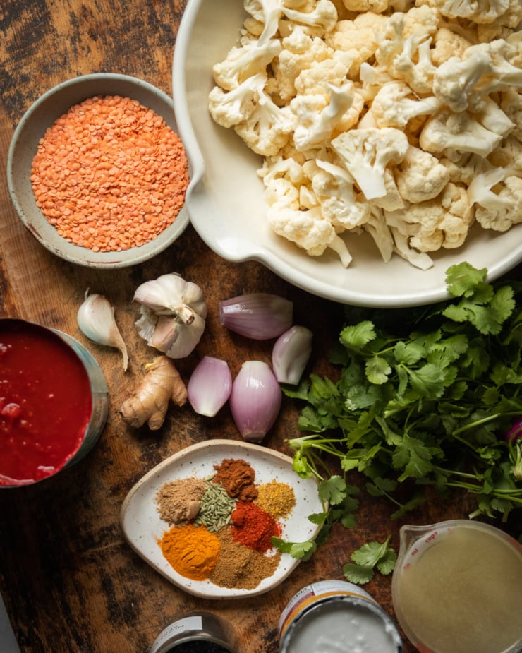 An overhead shot shows ingredients used in a cauliflower and coconut tomato sauce dish.