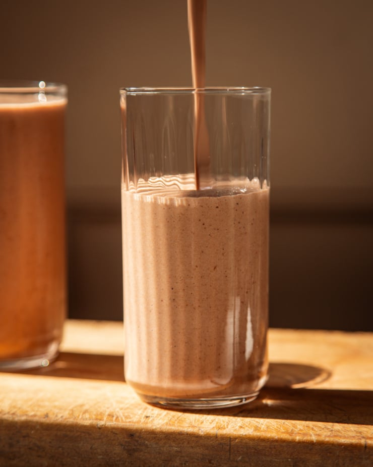 The front footage shows the chocolate smoothie pouring into a glass in bright sunlight.