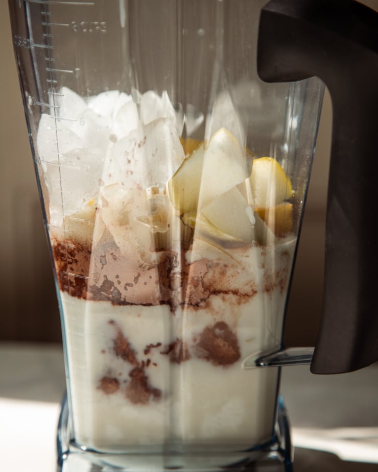 The front shot shows a mixer pitcher filled with ingredients to make smoothies.