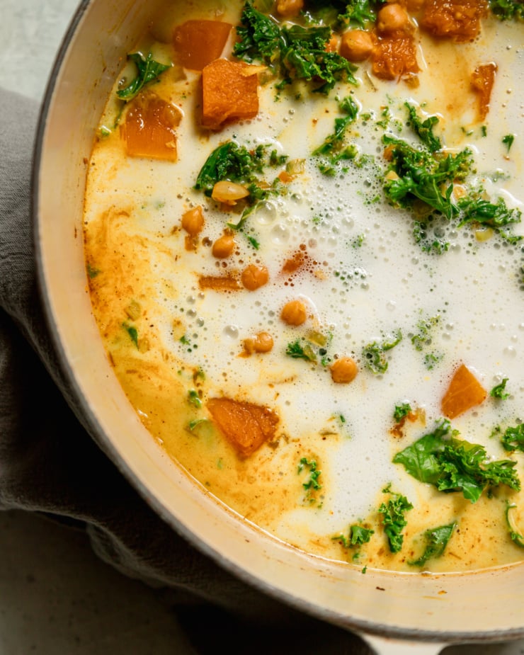 A close-up overhead shot shows that the coconut milk has been poured into the stew pot.