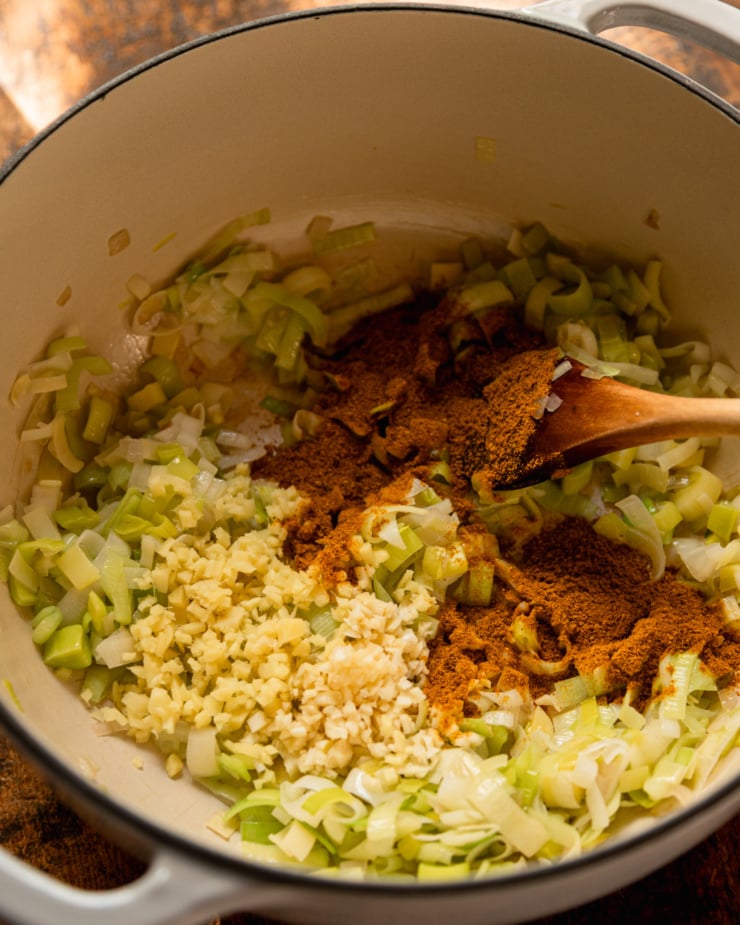 Top view shows leeks sautéed in a pan with ginger, garlic and curry powder.