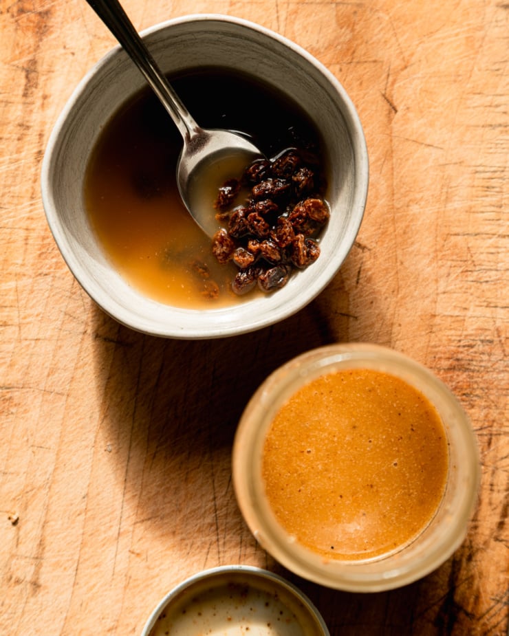 The overhead photo shows a bowl of raisins soaked in apple juice and a jar of peanut maple vinaigrette.
