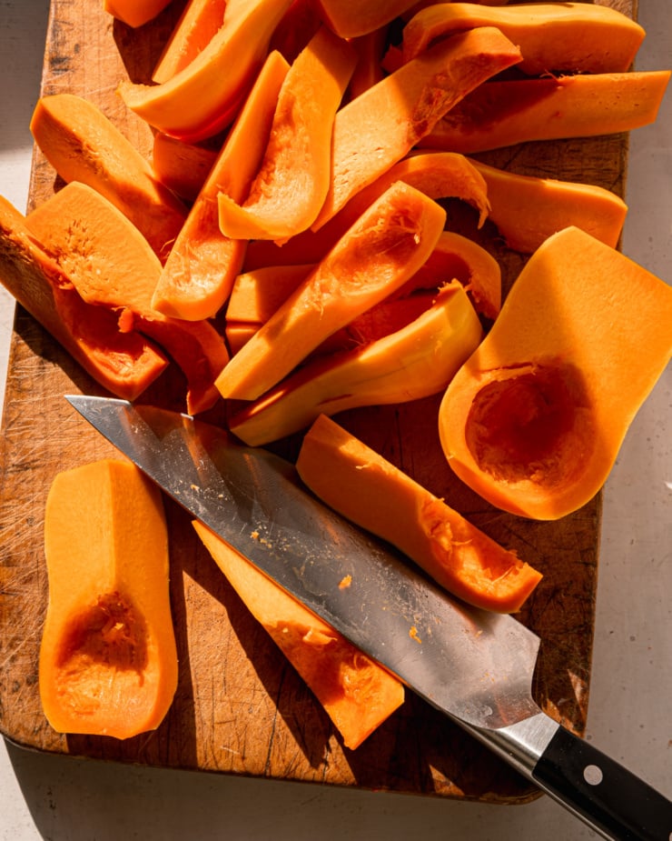 An overhead view shows a cutting board with a pile of sliced peach squash and a chef's knife.