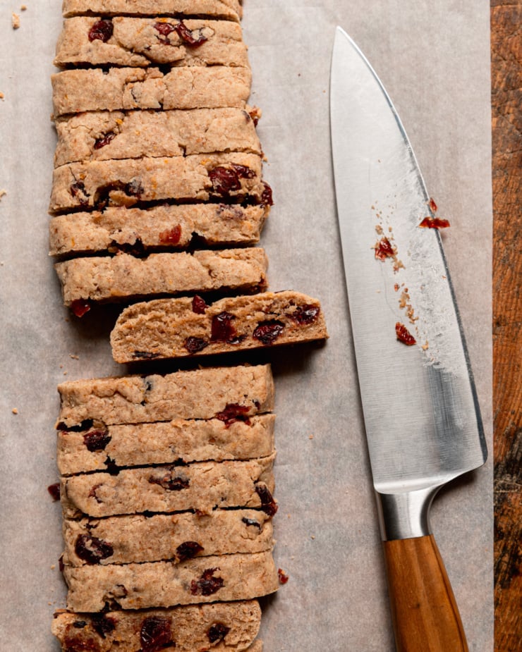 The top-down photo shows the shortbread being sliced ​​after the first baking. A chef's knife can be seen nearby.