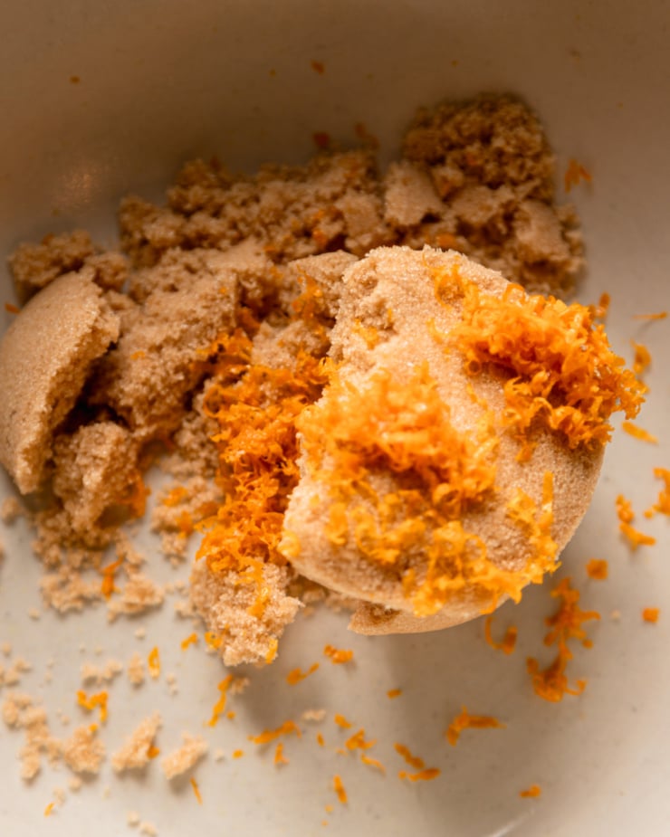 The top-down photo shows the bowl with light brown sugar and orange zest.
