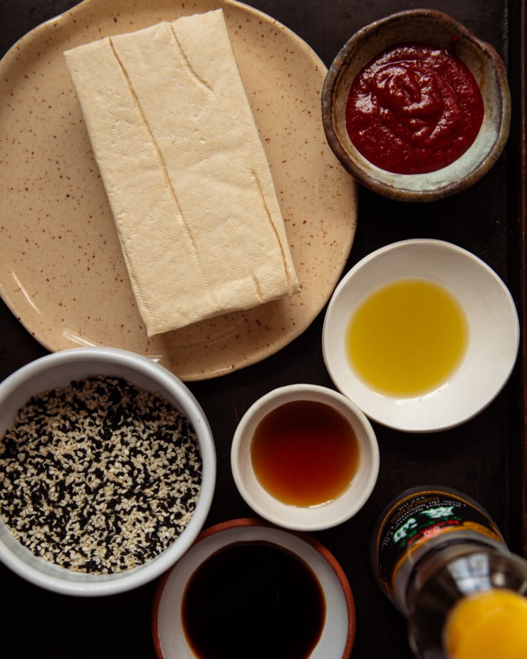 An overhead shot shows ingredients needed for a baked sesame tofu triangles recipe.