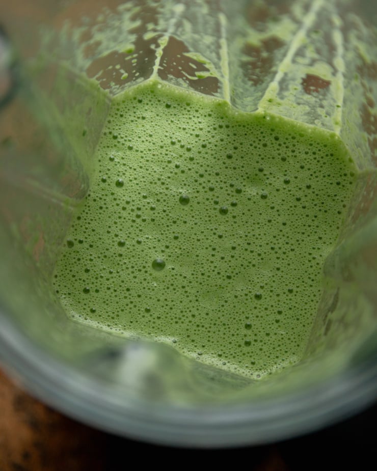 An overhead shot shows a blender jar with a green coconut milk mixture in it.