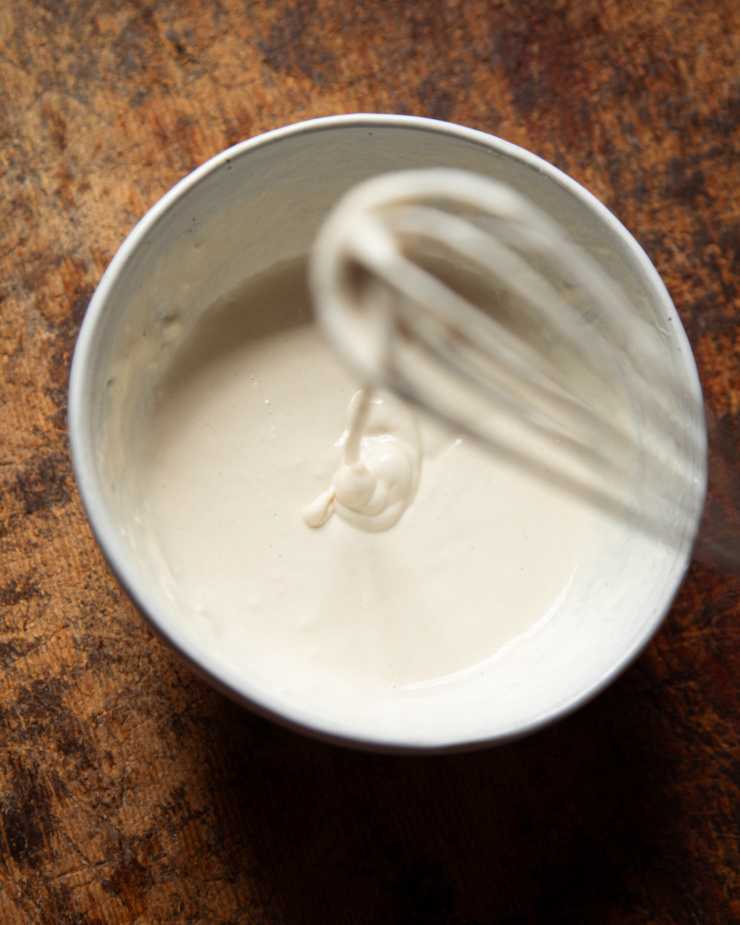 An overhead shot shows a flour and water mixture being whisked together in a small bowl.