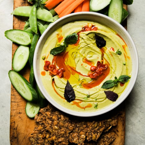 Garlic white bean dip with basil and Calabrian chili, served with carrots, cucumbers, snap peas, and seeded crackers.