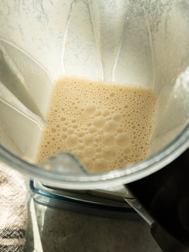 Blended cashew cream with miso and nutritional yeast in a blender jar.